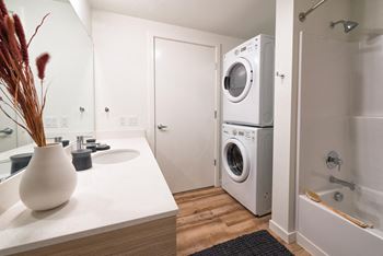 a kitchen with a washing machine and a sink and a washer and dryer at Wilcox, Seattle, 98107